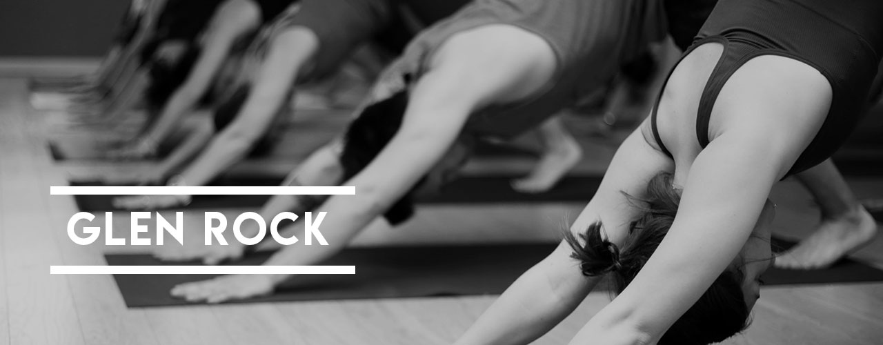 Powerflow Yoga Glen Rock students doing Downward Facing Dog during hot yoga.