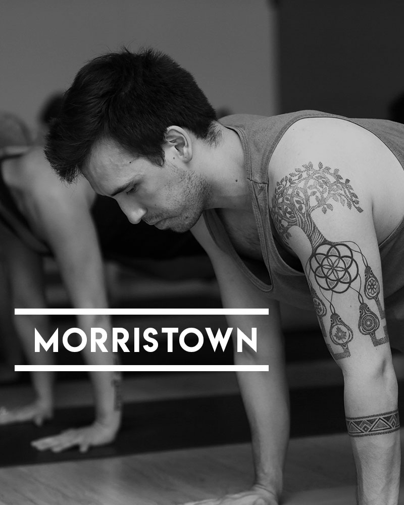 Powerflow Yoga Morristown student holding plank pose during hot yoga class.