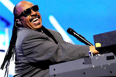 Stevie Wonder smiling while playing the piano